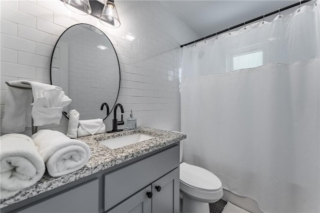 bathroom with toilet, tile walls, and vanity