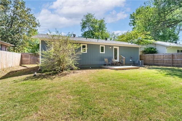 back of property featuring central air condition unit, a fenced backyard, a wooden deck, and a yard