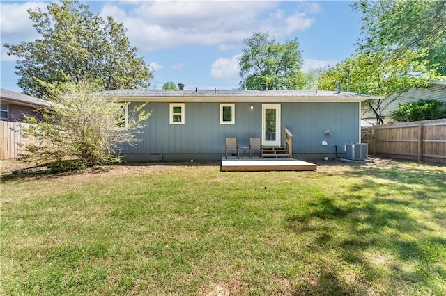 back of house with central AC unit, a wooden deck, fence, and a yard