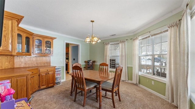 dining room with a chandelier, crown molding, baseboards, and light colored carpet