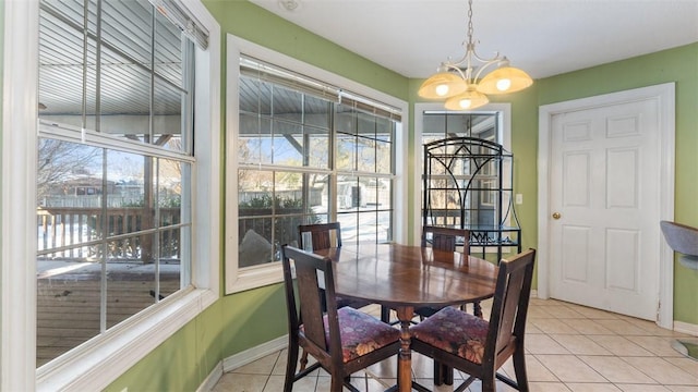 dining space featuring light tile patterned floors, plenty of natural light, baseboards, and a notable chandelier