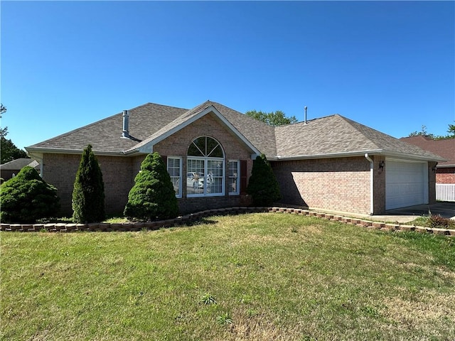 ranch-style home featuring brick siding, a shingled roof, concrete driveway, an attached garage, and a front yard