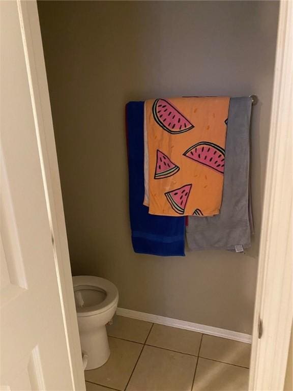 bathroom featuring baseboards, toilet, and tile patterned flooring