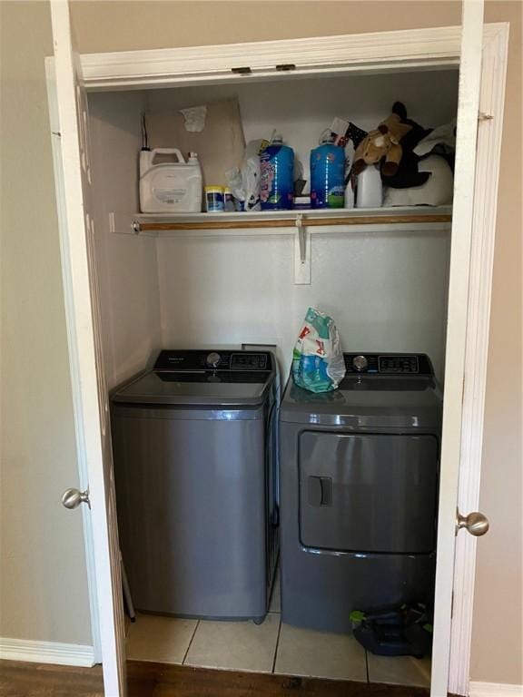 clothes washing area featuring tile patterned flooring, laundry area, and washer and dryer