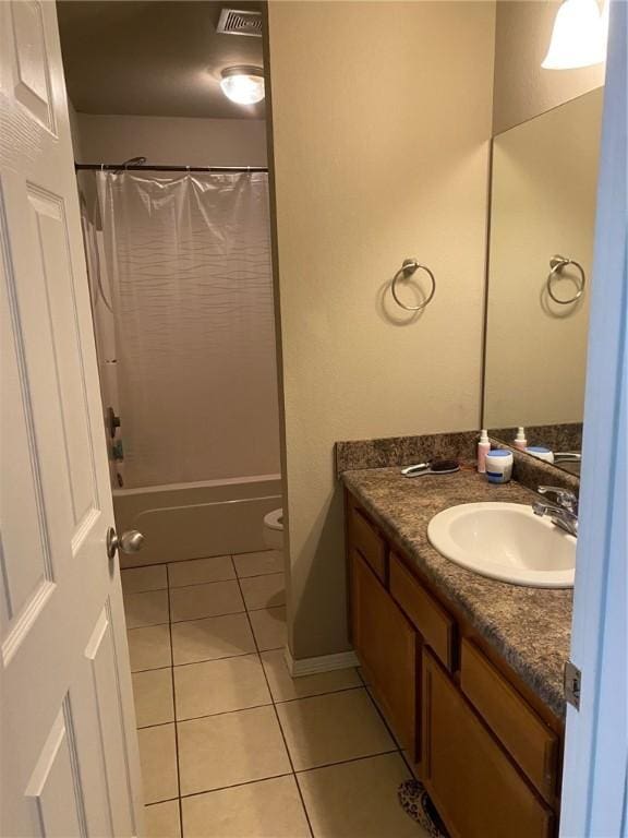 bathroom with visible vents, toilet, shower / bath combo with shower curtain, tile patterned floors, and vanity