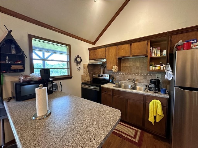 kitchen with lofted ceiling, light countertops, appliances with stainless steel finishes, a sink, and under cabinet range hood