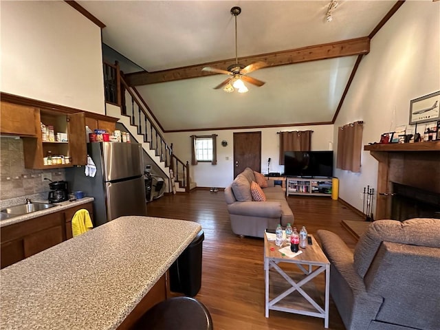 living room with vaulted ceiling with beams, a fireplace, stairway, and dark wood-style flooring