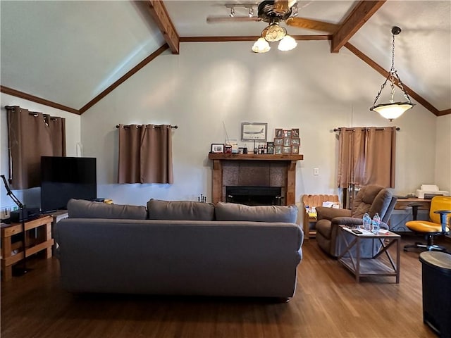 living area featuring a ceiling fan, a tile fireplace, ornamental molding, beamed ceiling, and wood finished floors