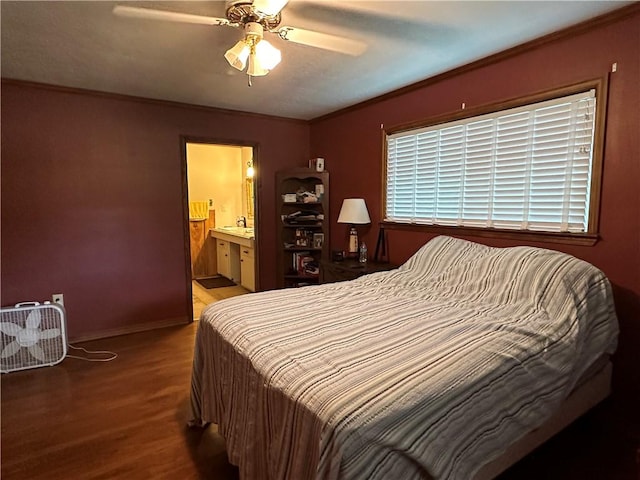 bedroom with baseboards, crown molding, ensuite bathroom, and wood finished floors