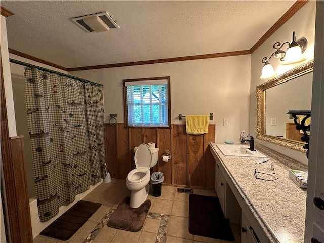 bathroom with wood walls, visible vents, a textured ceiling, and wainscoting