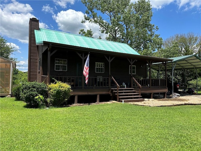 back of house featuring metal roof, a chimney, and a lawn