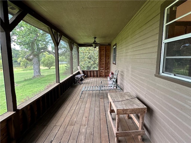 wooden deck with ceiling fan, a porch, and a lawn