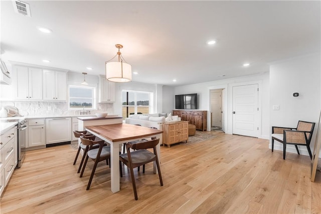 dining room with light wood-style flooring, visible vents, and recessed lighting