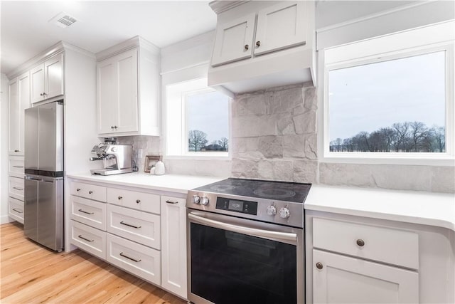 kitchen featuring stainless steel appliances, light countertops, visible vents, and white cabinets