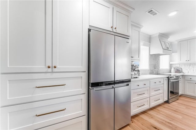 kitchen with white cabinets, visible vents, stainless steel appliances, and light countertops