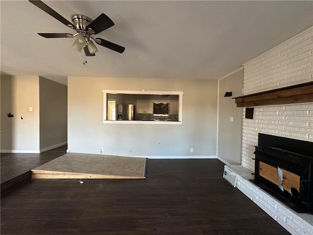 unfurnished living room with ceiling fan, a fireplace, wood finished floors, and baseboards