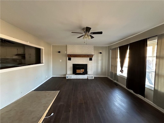 unfurnished living room featuring visible vents, baseboards, ceiling fan, dark wood-style flooring, and a brick fireplace