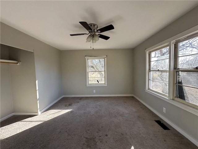 spare room featuring a ceiling fan, carpet flooring, visible vents, and baseboards