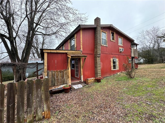 view of side of property featuring a chimney and fence