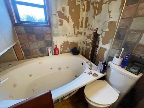 bathroom with a jetted tub, toilet, and wallpapered walls