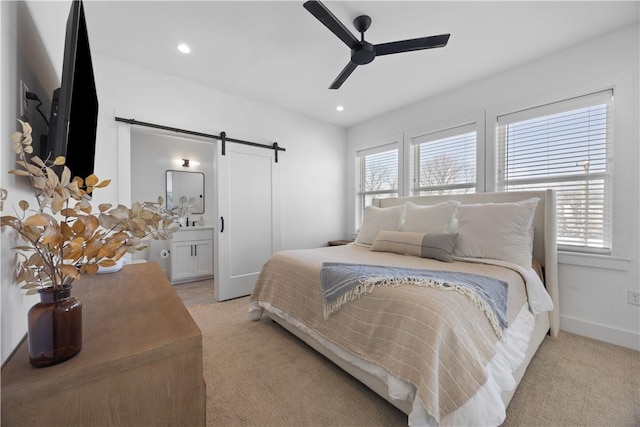 bedroom featuring a barn door, multiple windows, and light colored carpet