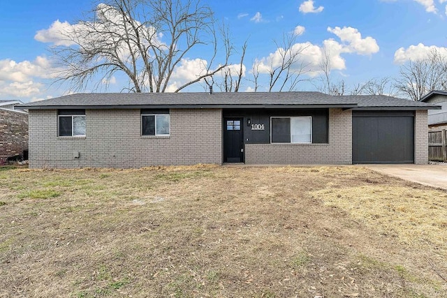 ranch-style house featuring a garage, driveway, and brick siding