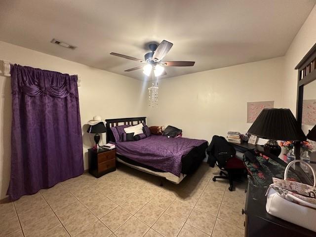 bedroom featuring light tile patterned floors, visible vents, and a ceiling fan