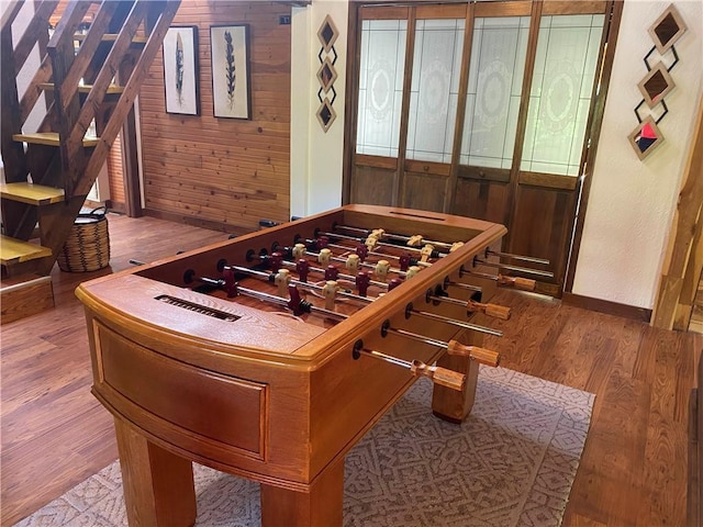 game room with baseboards and wood finished floors