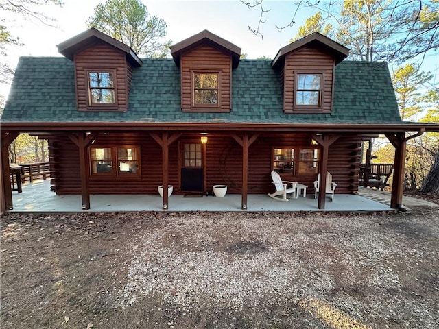 rear view of property featuring a shingled roof and log exterior