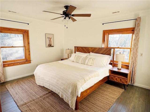 bedroom with baseboards, visible vents, dark wood finished floors, and a ceiling fan