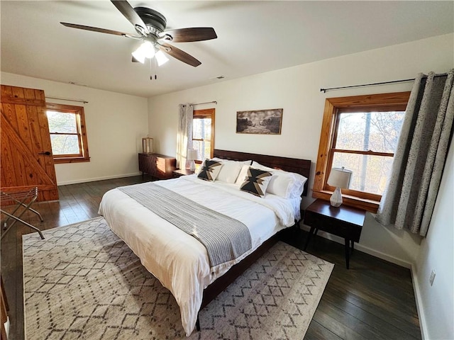 bedroom featuring multiple windows, baseboards, and dark wood-style flooring