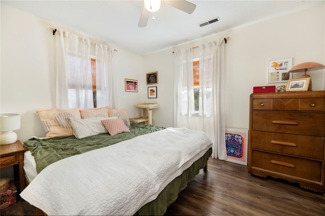 bedroom with dark wood-style flooring, visible vents, and ceiling fan