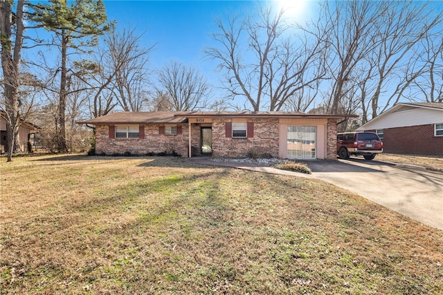 ranch-style home with a garage, concrete driveway, brick siding, and a front yard