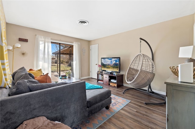 living room featuring dark wood-type flooring, visible vents, and baseboards