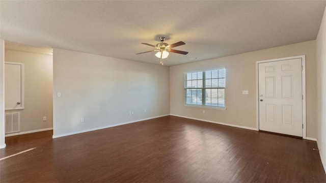 unfurnished room with a ceiling fan, baseboards, visible vents, and dark wood-style flooring