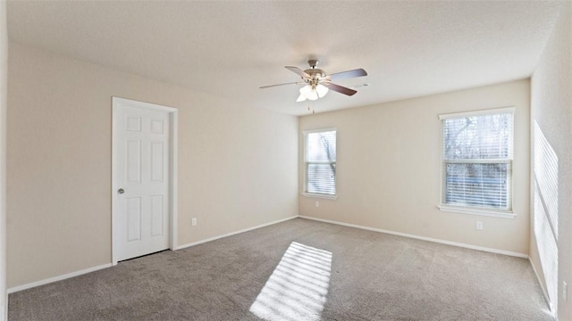 unfurnished room with light colored carpet, ceiling fan, and baseboards