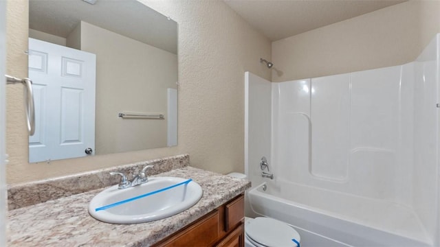 full bath with a textured wall, vanity, toilet, and shower / bathtub combination