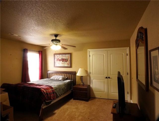 bedroom with visible vents, light carpet, a textured ceiling, a closet, and ceiling fan