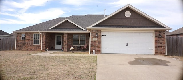 view of front of property featuring a front yard, fence, an attached garage, concrete driveway, and brick siding