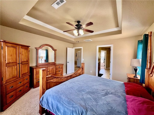 bedroom featuring a tray ceiling and visible vents