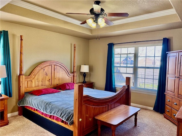 bedroom featuring a textured ceiling, a tray ceiling, carpet flooring, and ornamental molding