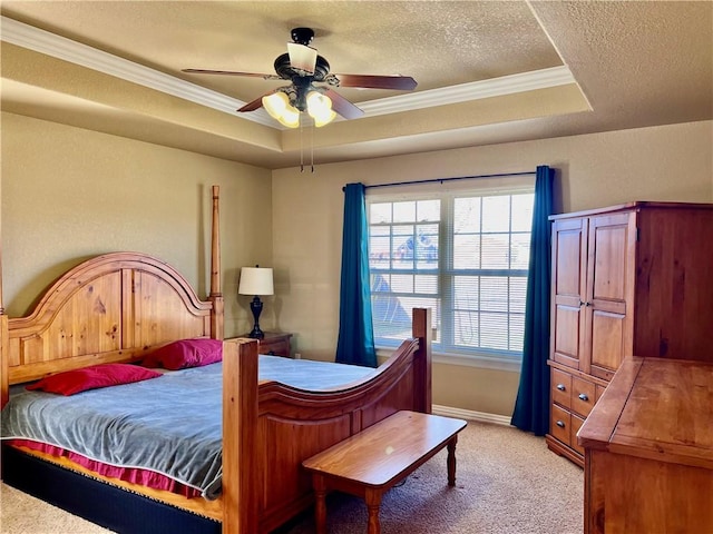 bedroom featuring ornamental molding, a tray ceiling, a textured ceiling, carpet, and ceiling fan