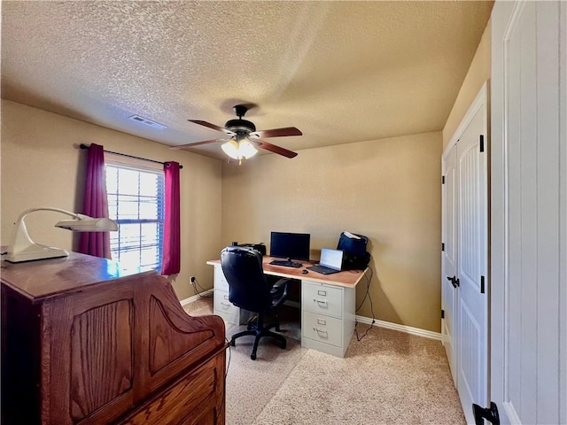 office with visible vents, baseboards, light carpet, a textured ceiling, and a ceiling fan