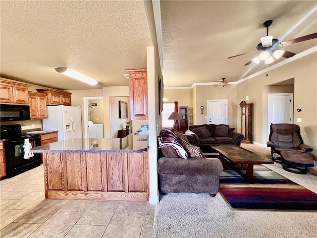 kitchen with ceiling fan, open floor plan, washing machine and dryer, a peninsula, and black appliances