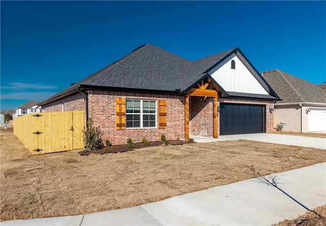 view of front of property with brick siding, driveway, an attached garage, and roof with shingles