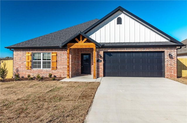 view of front of property with a garage, concrete driveway, brick siding, and a front lawn