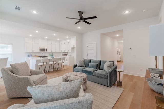 living area featuring recessed lighting, visible vents, and light wood-style flooring