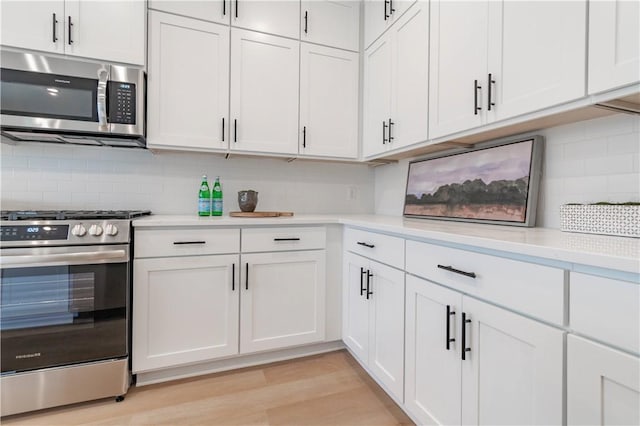 kitchen featuring stainless steel appliances, light wood finished floors, light countertops, and white cabinetry