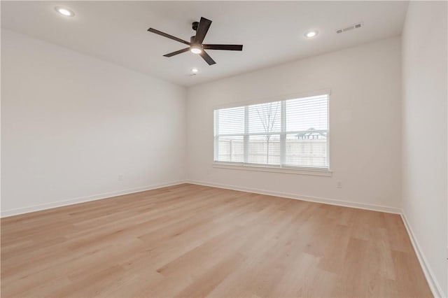 unfurnished room featuring light wood-style floors, baseboards, and visible vents