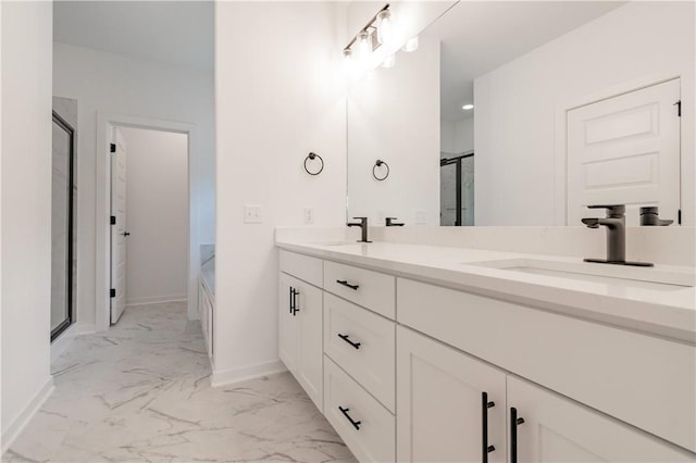 full bathroom with marble finish floor, double vanity, a sink, and baseboards